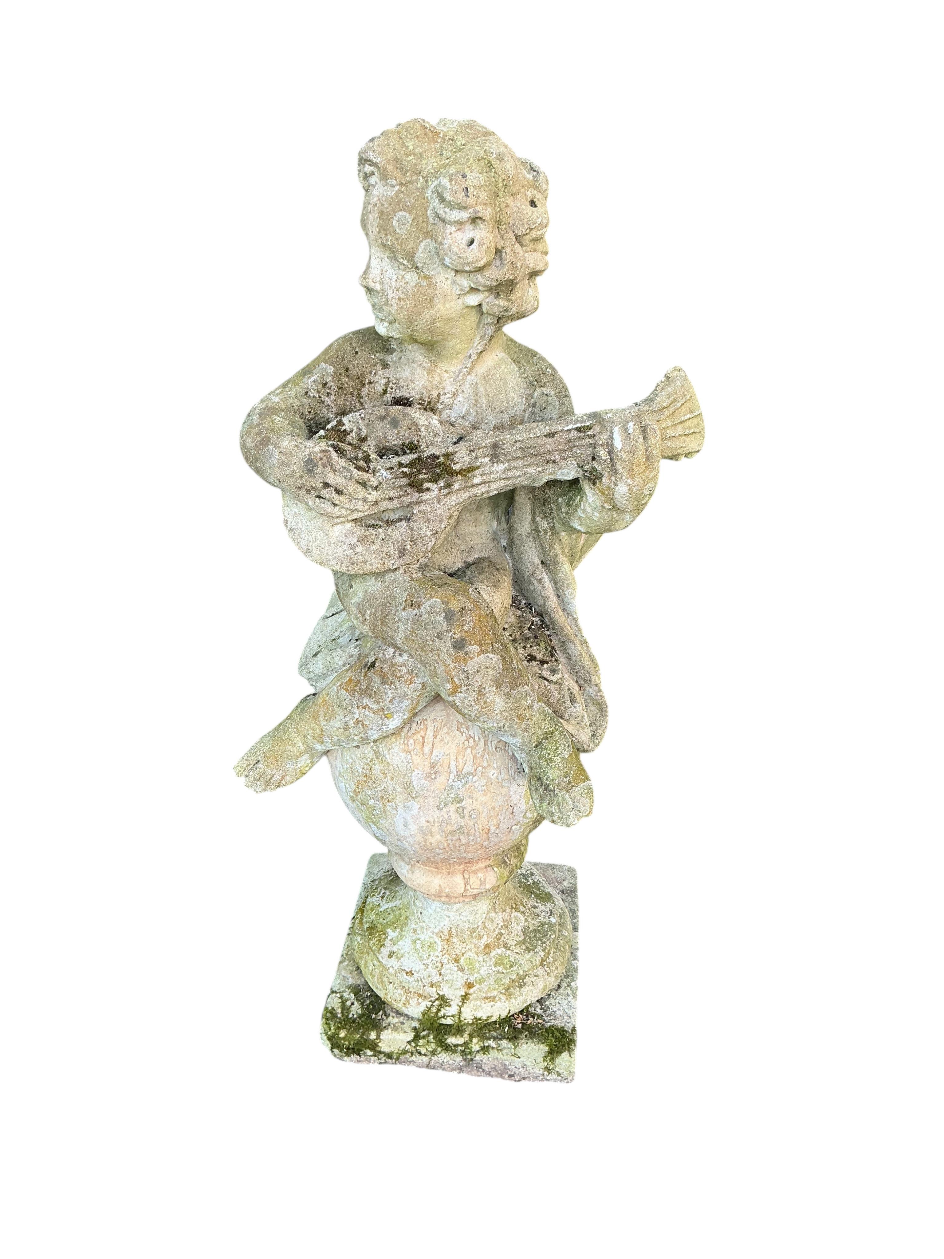 A reconstituted stone musical cherub garden ornament, height 100cm